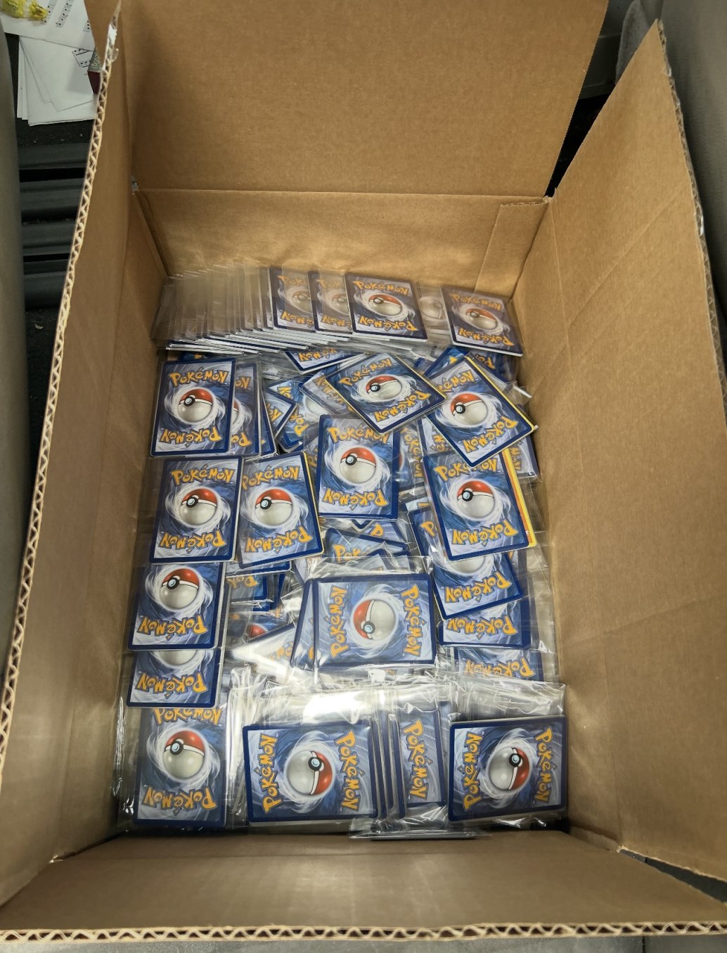 An open box filled with individually wrapped Pokémon card packs.